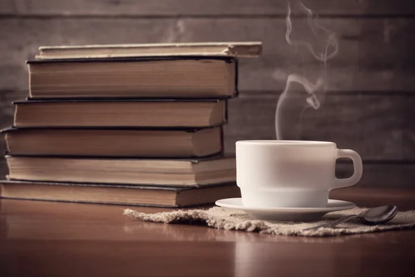 Old books on wooden background with cup of coffee — Stock Photo, Image