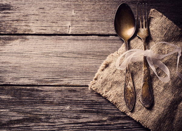 Old fork and spoon on wooden background