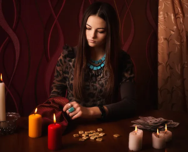 Jonge vrouw met runen en waarzeggerij kaarten op kamer — Stockfoto