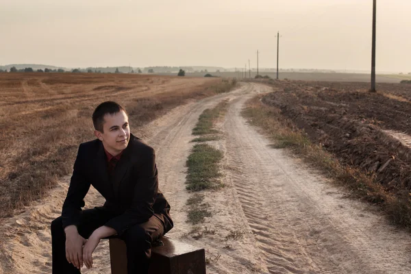 Jeune homme avec des bagages sur une route — Photo