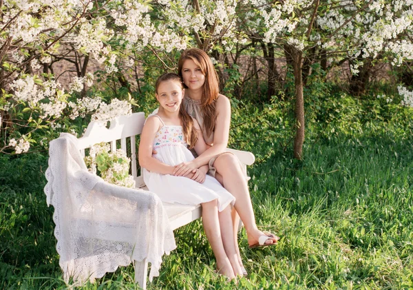 Glad mamma med dotter i vårträdgård — Stockfoto