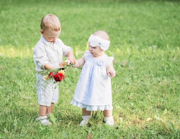 Dvě děti s květinami — Stock fotografie