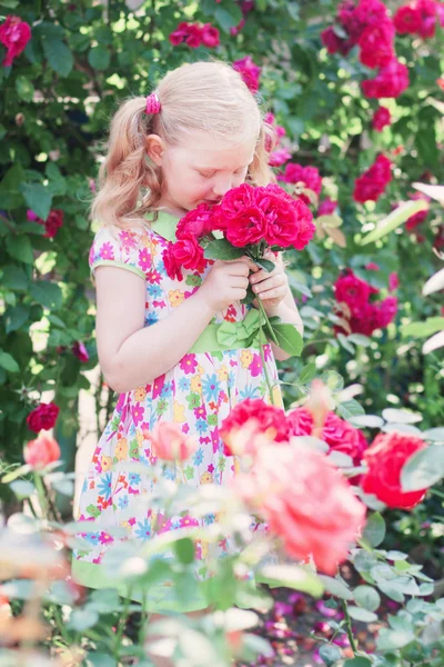 Happy girl with roses in garden — Stock Photo, Image