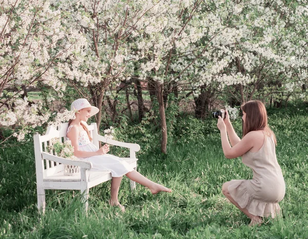 Madre fotografiando a su hija en el jardín de primavera — Foto de Stock