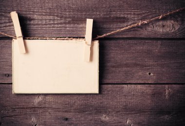 eski kağıt bağlamak için ip ile ahşap arka plan üzerinde elbise pimleri