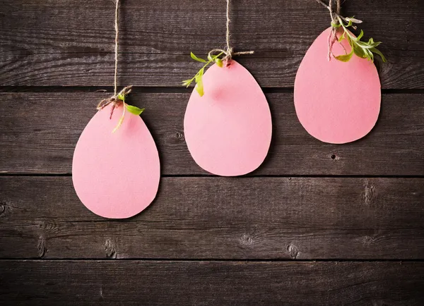 Huevos rosados hechos de papel sobre fondo de madera —  Fotos de Stock