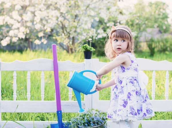 Flicka vattning vårblommor — Stockfoto