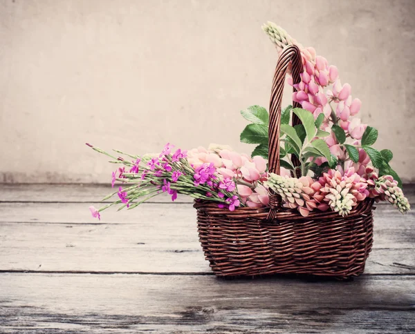 Kwiaty w koszyku na stary tło — Zdjęcie stockowe