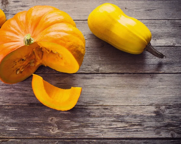 Pumpkins with leaves on wooden board — Stock Photo, Image