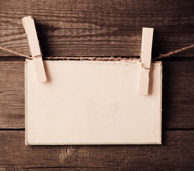 eski kağıt bağlamak için ip ile ahşap arka plan üzerinde elbise pimleri