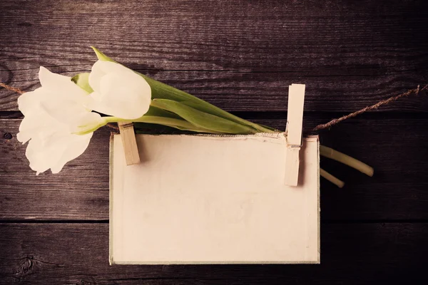 Papier hechten aan touw met kleren pinnen en tulpen op houten bac — Stockfoto