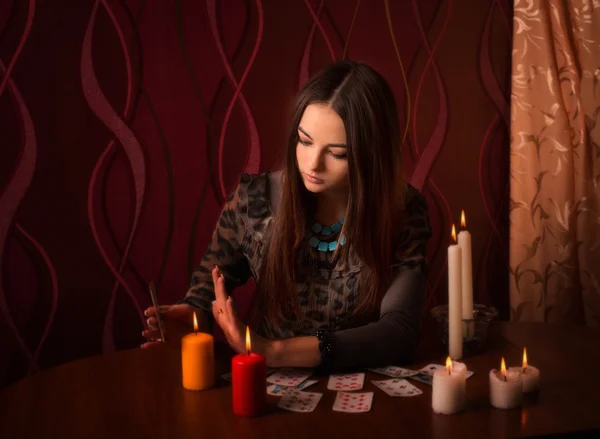 Mujer joven con tarjetas de adivinación en la habitación —  Fotos de Stock