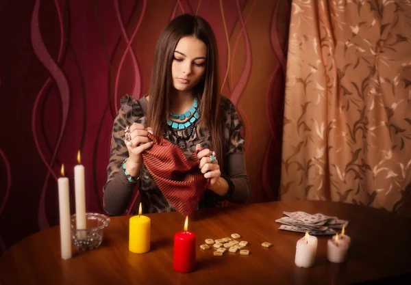 Mujer joven con runas y tarjetas de adivinación en la habitación — Foto de Stock