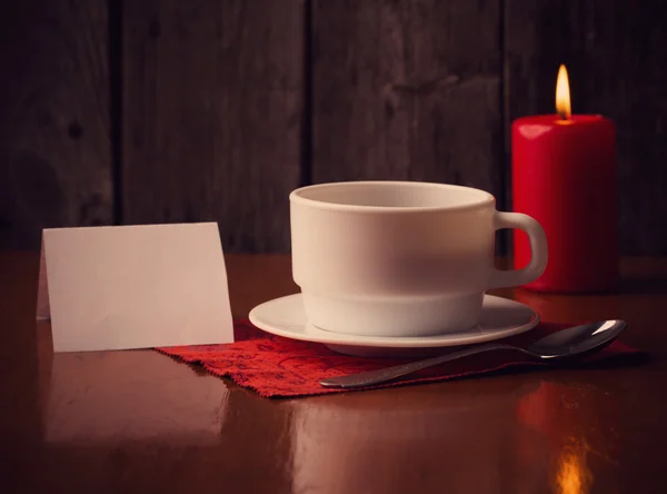 Tasse de café, bougie et papier sur fond en bois — Photo