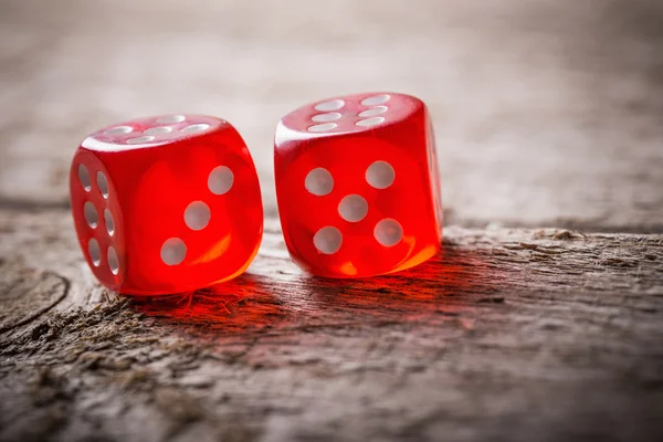 Pair of thrown red dices on old wooden table — Stock Photo, Image