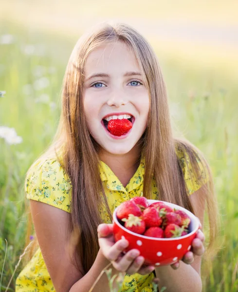 Fille heureuse avec fraise en plein air — Photo