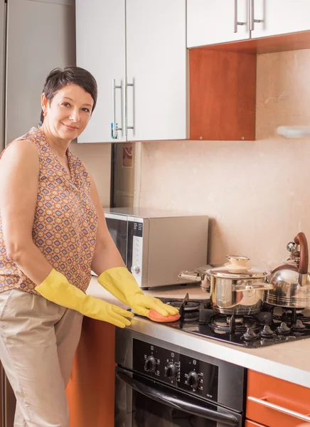 Mogen kvinna gör hushållsarbete i köket — Stockfoto