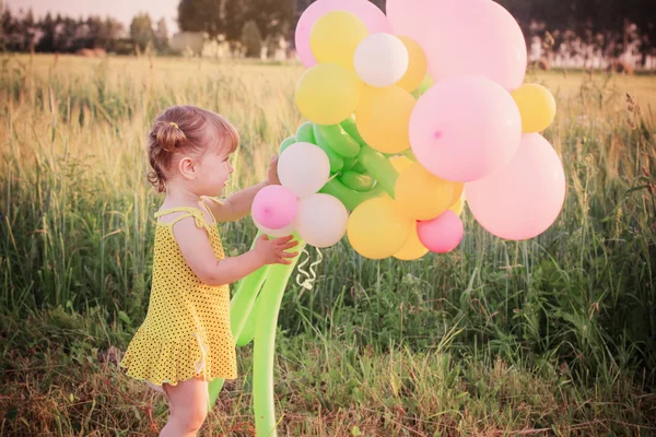 Flicka med ballonger utomhus — Stockfoto