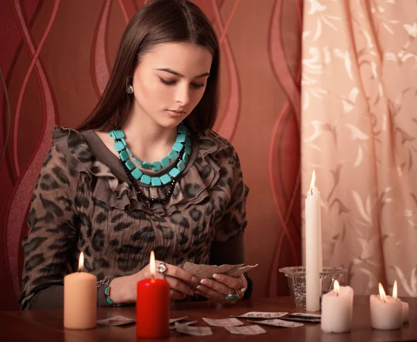 Mujer joven con tarjetas de adivinación en la habitación —  Fotos de Stock