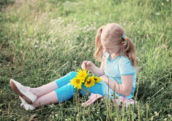 Meisje met zonnebloemen buiten — Stockfoto