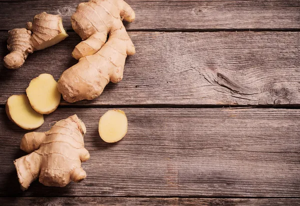 Ginger root sliced on wooden background — Stock Photo, Image