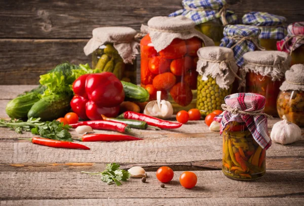 Preserved and fresh vegetables on wooden background — Stock Image Preserved and fresh vegetables on wooden background Stock Picture