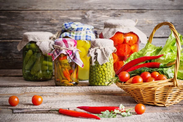 Preserved and fresh vegetables on wooden background — Stock Image Preserved and fresh vegetables on wooden background Stock Image