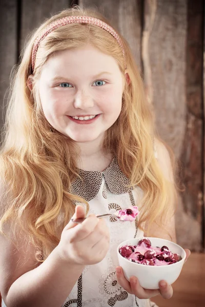 Щаслива дівчина з десертом на дерев'яному фоні — стокове фото