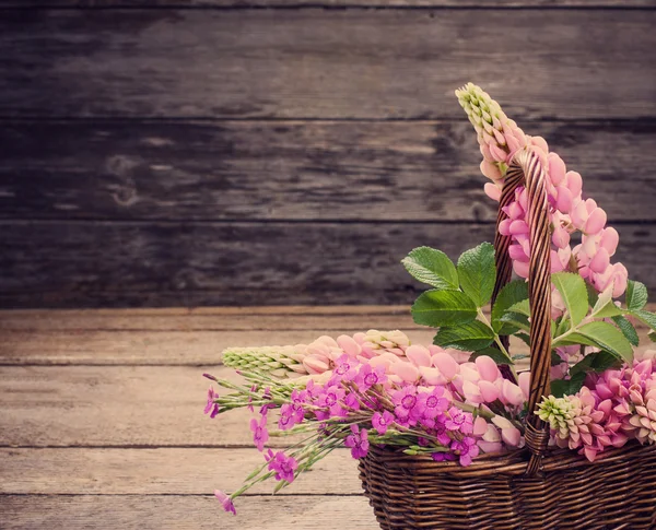 Blommor i korg på gammal bakgrund — Stockfoto