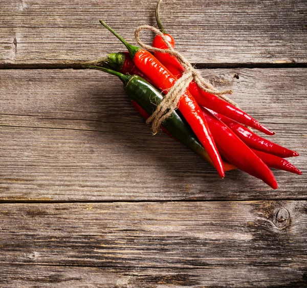 Röd chilipeppar på gamla träbord — Stockfoto
