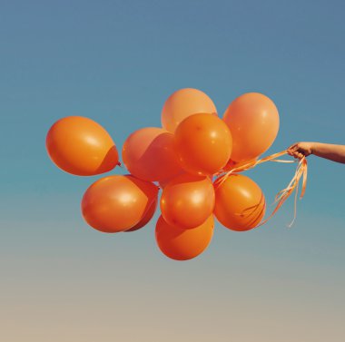 Mavi gökyüzü üzerinde turuncu balonlar