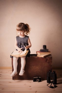 Küçük kız kitap okuyor.