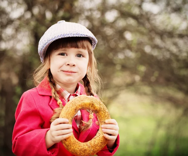 Grappig meisje met donut buiten — Stockfoto