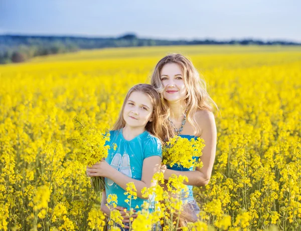 Happy women and girl in rape field — Stock Photo, Image