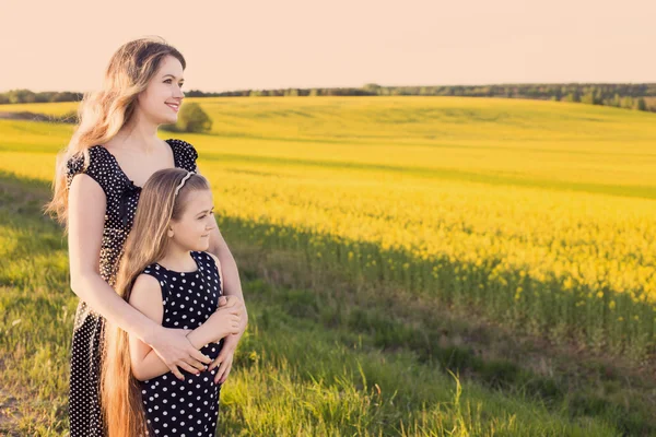 Glada kvinnor och flickan i rapsfält — Stockfoto