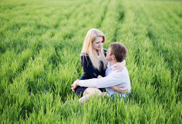 Jong paar zitten op groen gras — Stockfoto