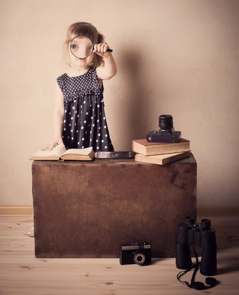 拡大鏡と本を読む小さな女の子 — ストック写真