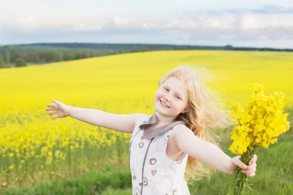 Menina engraçada bonito no campo de estupro — Fotografia de Stock