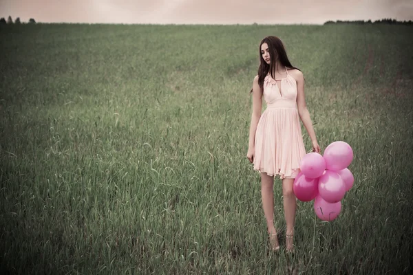 Hermosas mujeres jóvenes con globos rosados — Foto de Stock