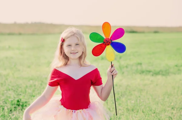 Menina segurando uma flor de brinquedo — Fotografia de Stock