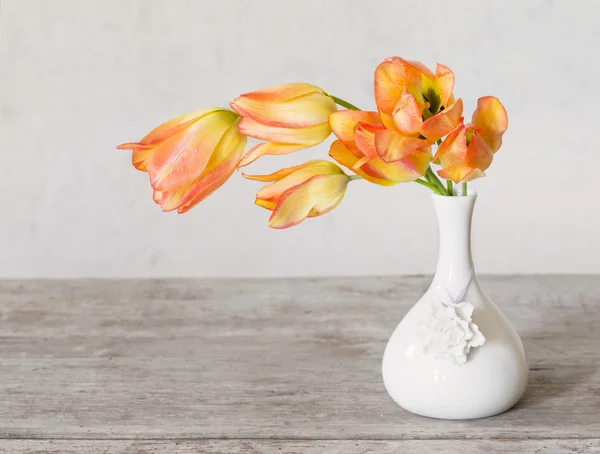 Tulipanes en jarrón blanco sobre mesa de madera —  Fotos de Stock
