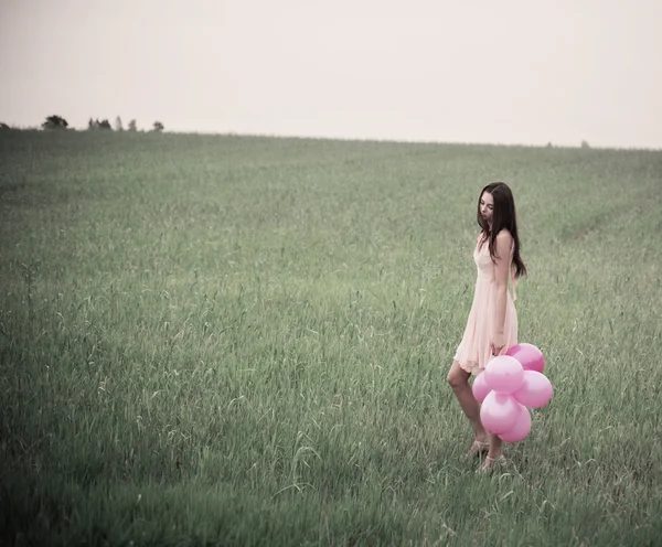 年轻貌美的女性，与粉红色的气球户外 — 图库照片