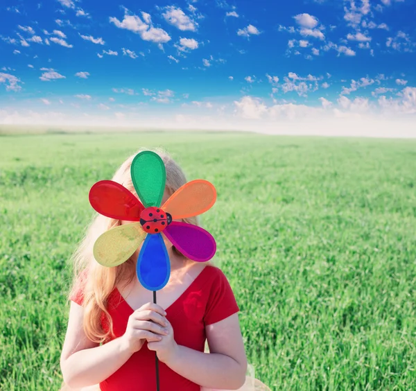 Girl holding a toy flower — Stock Photo, Image