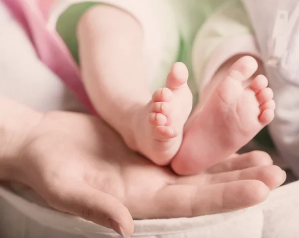 Babyfüße in der Hand der Mutter — Stockfoto