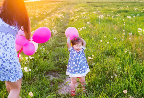 Baby en moeder met ballonnen buiten — Stockfoto