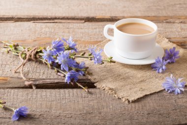 Cup of tea with chicory on wooden background clipart
