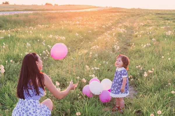 Baby en moeder met ballonnen buiten — Stockfoto