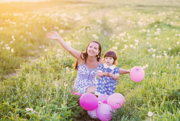 Baby och mamma med ballonger utomhus — Stockfoto