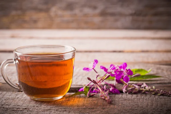 Cup of tea with willow-herb on wooden background — Stock Photo, Image