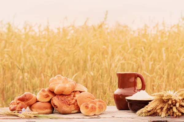 Chléb na dřevěný stůl na pole — Stock fotografie